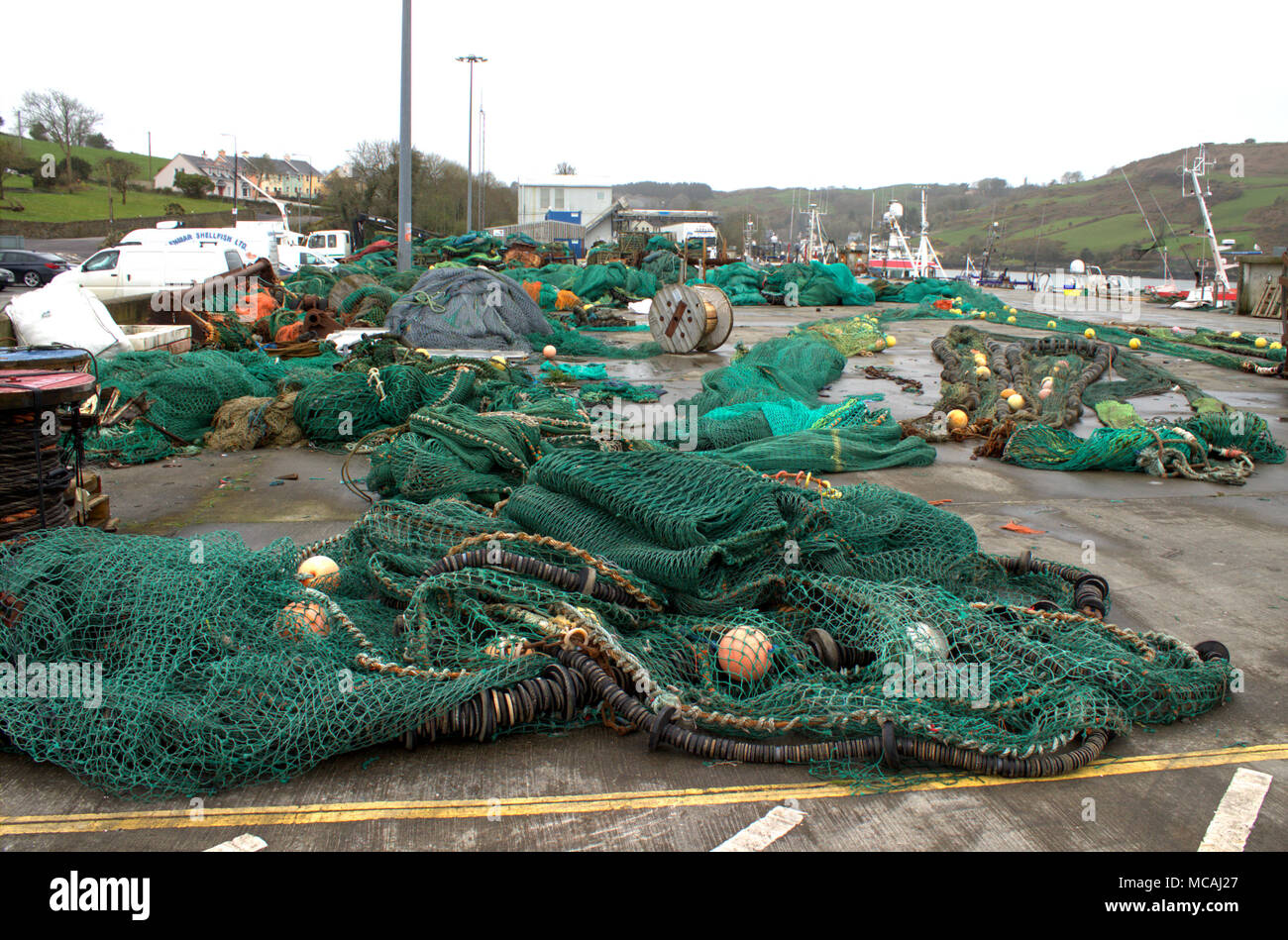 Fishermens Kai voll von alten Fischernetzen und Fanggeräte und Schleppnetzen, nach Produkt eines langen fischereiflotte. West Cork, Irland Stockfoto