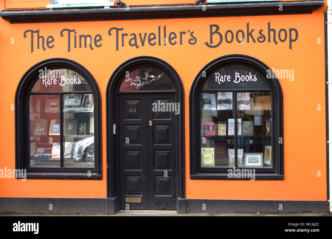 Farbenfrohe orange bunt bemalte Geschäft Verkauf seltener Bücher auf der Hauptstraße in einer irischen Stadt, skibbereen, West Kork, irland. Stockfoto