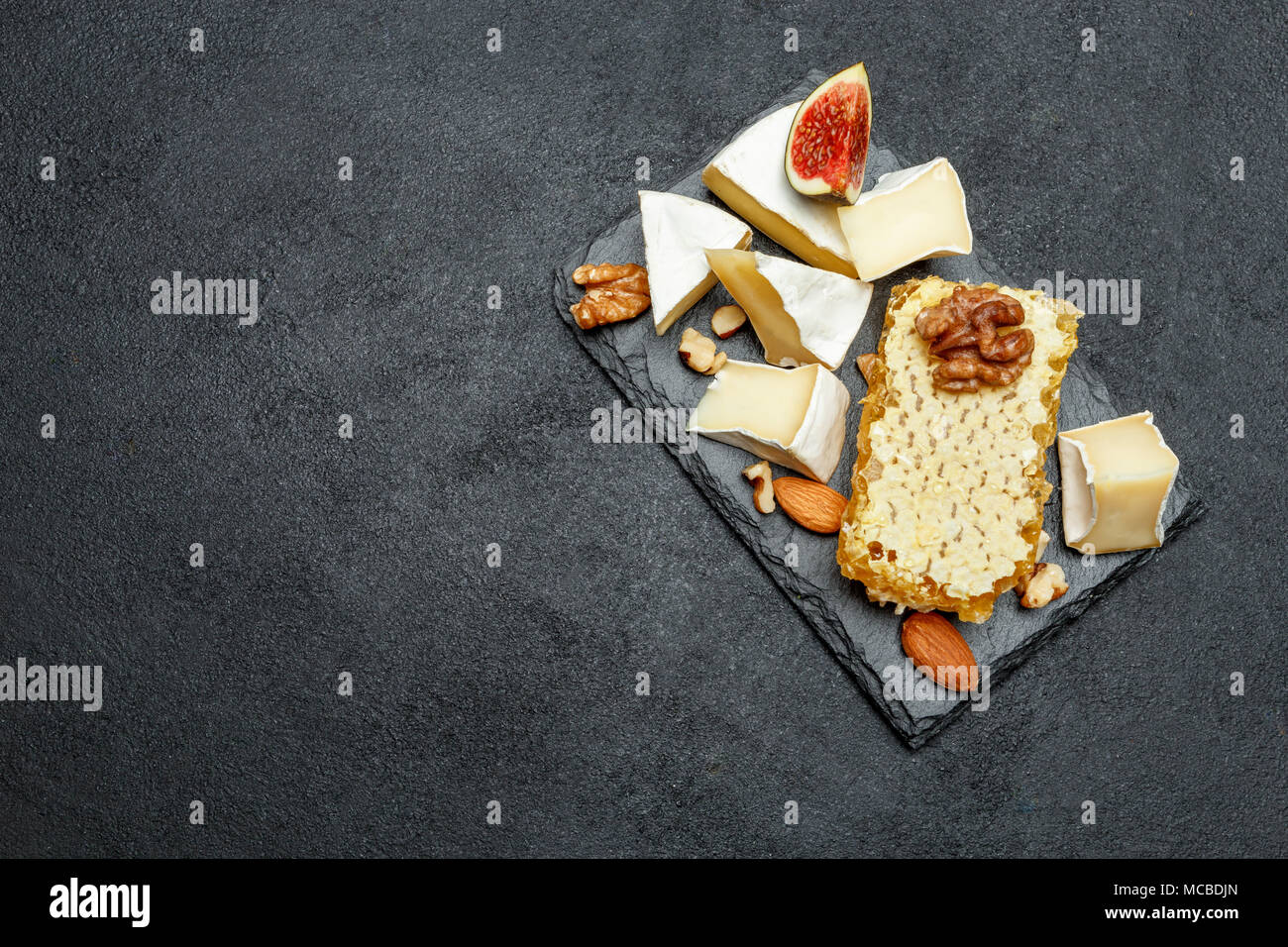 Camembert Käse mit Honig, Feigen, Walnüsse auf Stein board Stockfoto