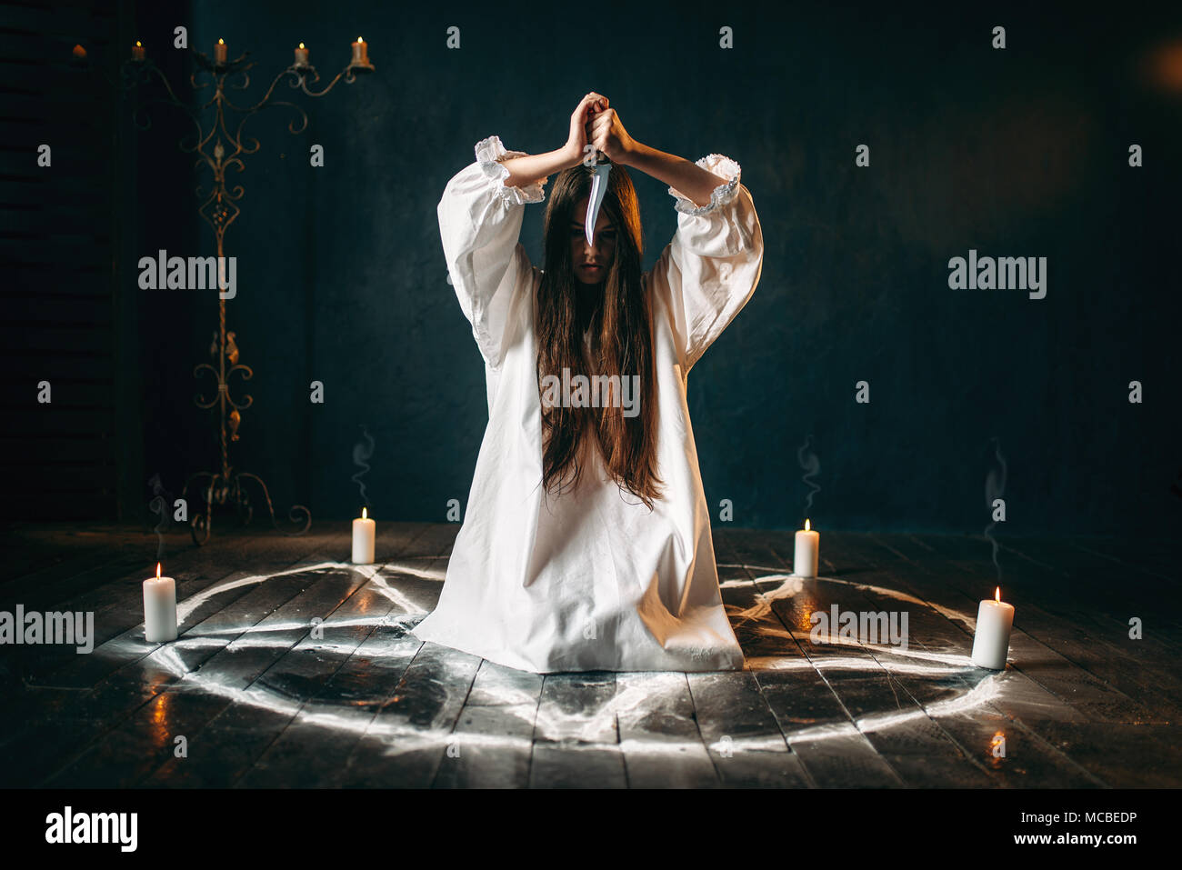 Frau mit Messer in pentagramm Kreis sitzen Stockfoto