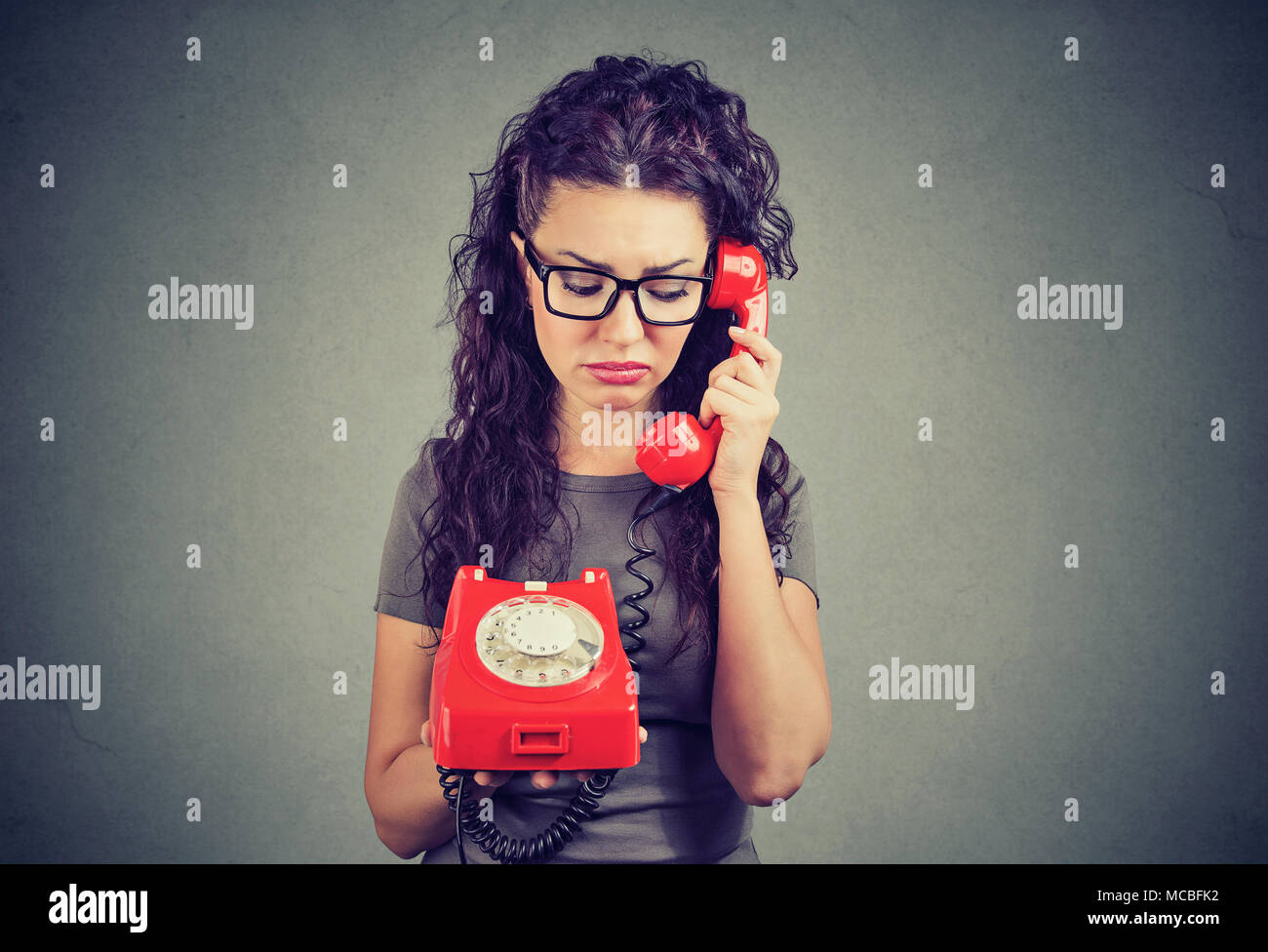Ernste traurige junge Frau mit unangenehmen Anruf Stockfoto