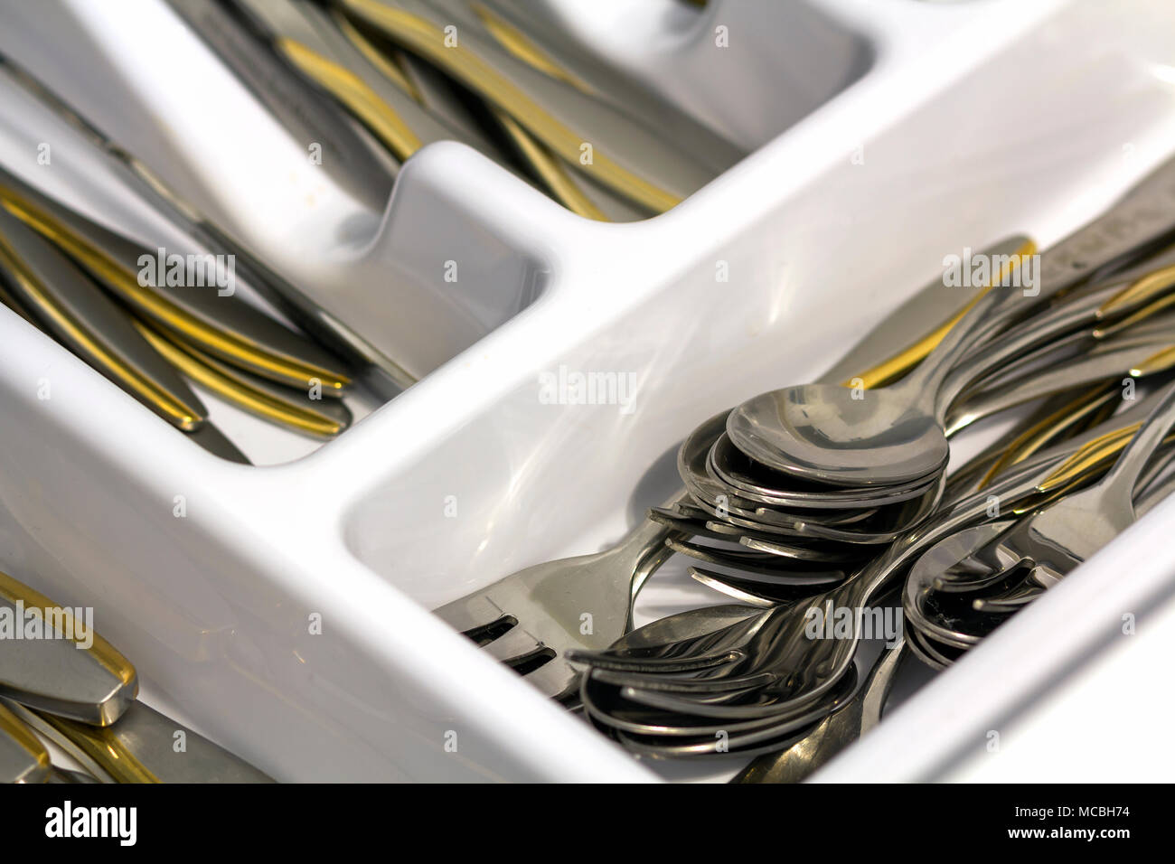 In der Nähe des Neuen sauber glänzend Silber oder Edelstahl Besteck mit goldener Dekoration ordentlich in offenen drrawer der modernen Küche Schaltschrank angeordnet. Comfortabl Stockfoto