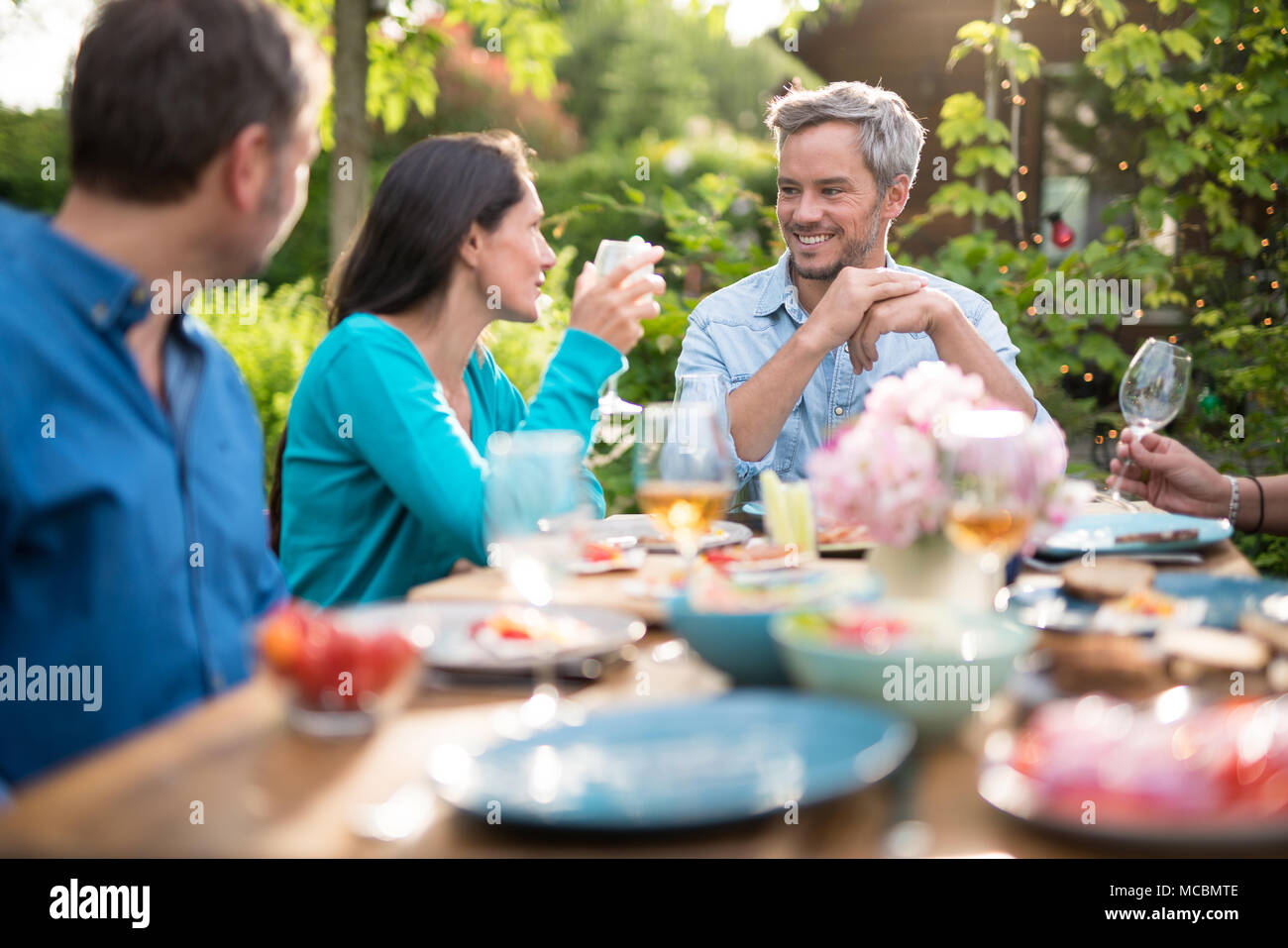 Freunde um den esstisch Fotos und Bildmaterial in hoher Auflösung Alamy