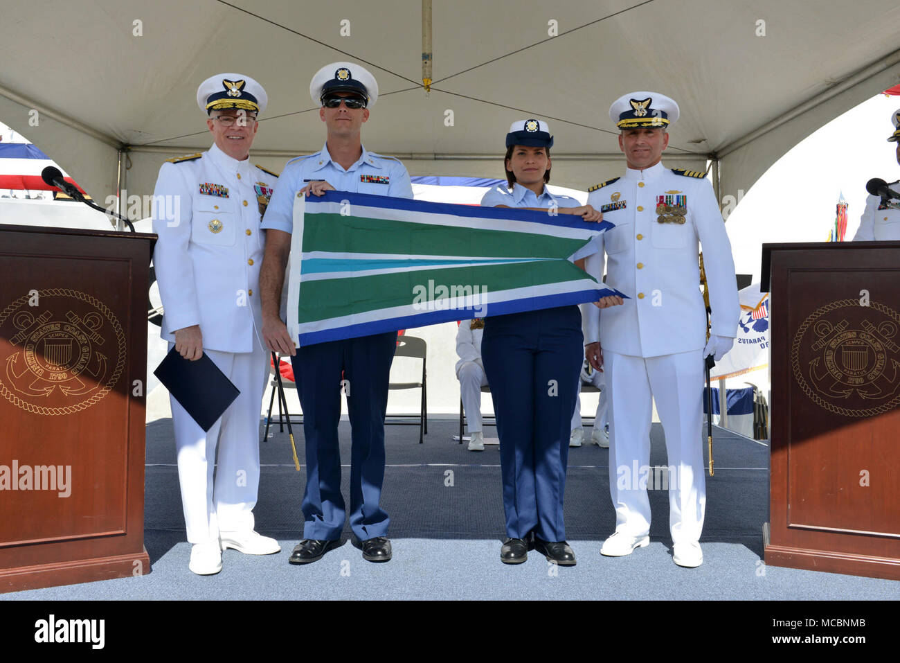 Coast Guard Vice Adm. Fred Midgette, Pazifischer Raum Commander, und Kapitän Steven Whittrock, Coast Guard Cutter Sherman's kommandierenden Offizier, stand mit Sherman Crewmitglieder nach midgette das Schermesser mit der meritorious Unit commendation während des Sherman Stilllegung Zeremonie in Honolulu, März 29, 2018 ausgezeichnet. Sherman Crewmitglieder führten ihre endgültige Patrouille im Beringmeer und überwand einen Vielzahl von technischen Herausforderungen, ohne auch nur eine einzige operationelle Tag während der patrouille. Stockfoto