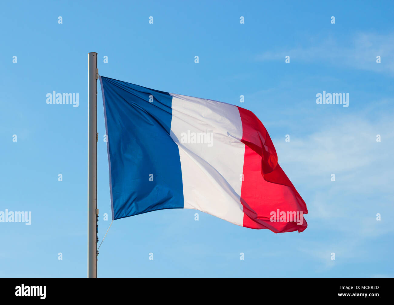 Französische Flagge in einem lebhaften Brise flattern vor einem strahlend blauen Himmel im Sommer Hintergrund. Stockfoto