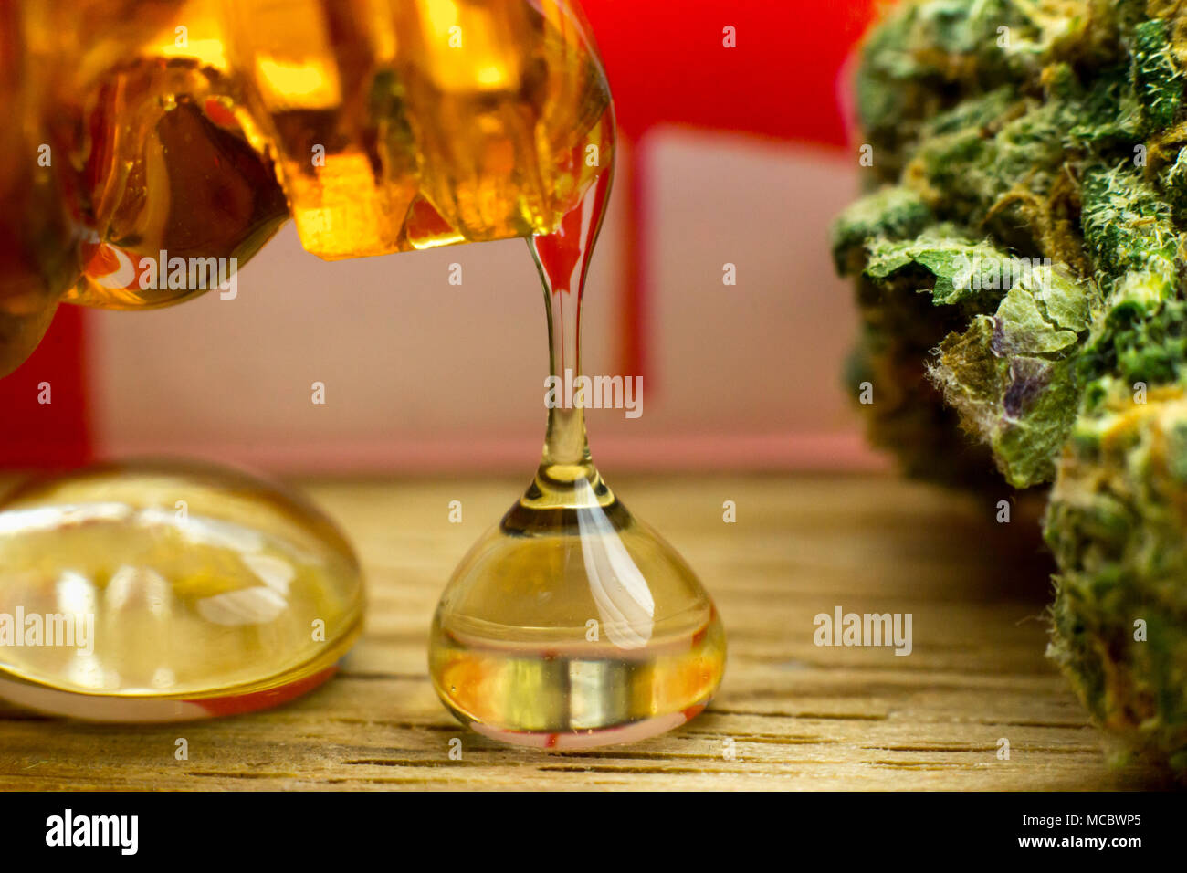 Makroblumen-Cannabis und Öl auf dem Eichentisch mit kanadischer Flagge im Hintergrund. Stockfoto