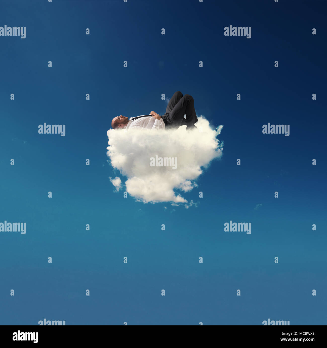 Betonte Unternehmer entspannt auf eine weiche Wolke Stockfoto