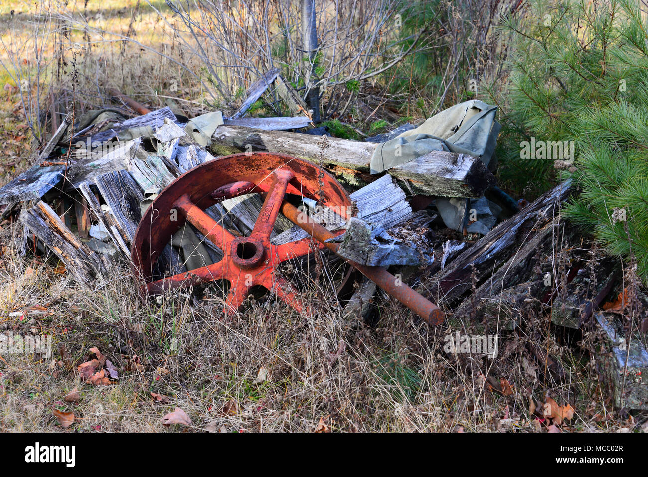 Eine alte Metall Wagen Rad und Achse auf einem Stapel von alten hölzernen Platten aus der verlassenen Waggon. Stockfoto