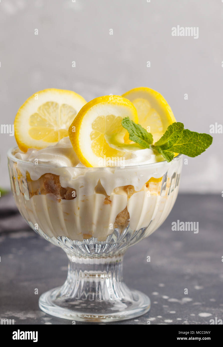 Zitronen Dessert, Zitrone Kleinigkeit, Käsekuchen, Schlagsahne, Parfait. Obst Mousse in Glas auf einem hellen Hintergrund. Stockfoto