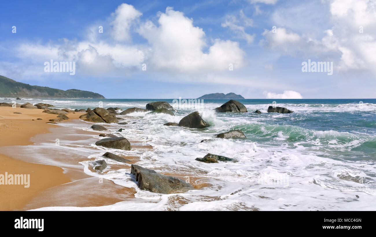Küste mit Felsen und Wellen an der tropischen Insel Hainan, Sanya, China Stockfoto