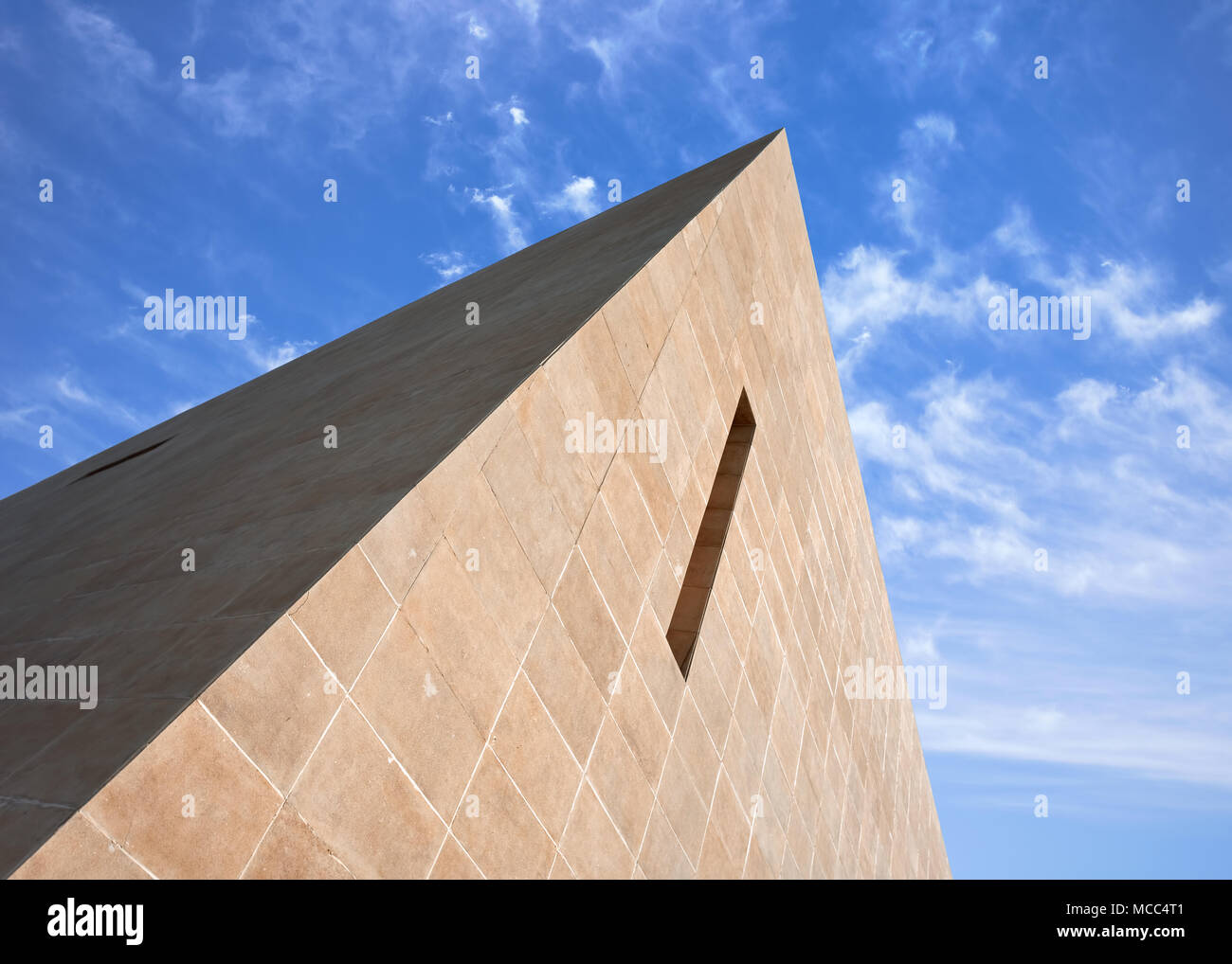 Pyrmid geformtes, modernes Gebäude gegen einen blauen Himmel mit dramatischen Wolken Stockfoto