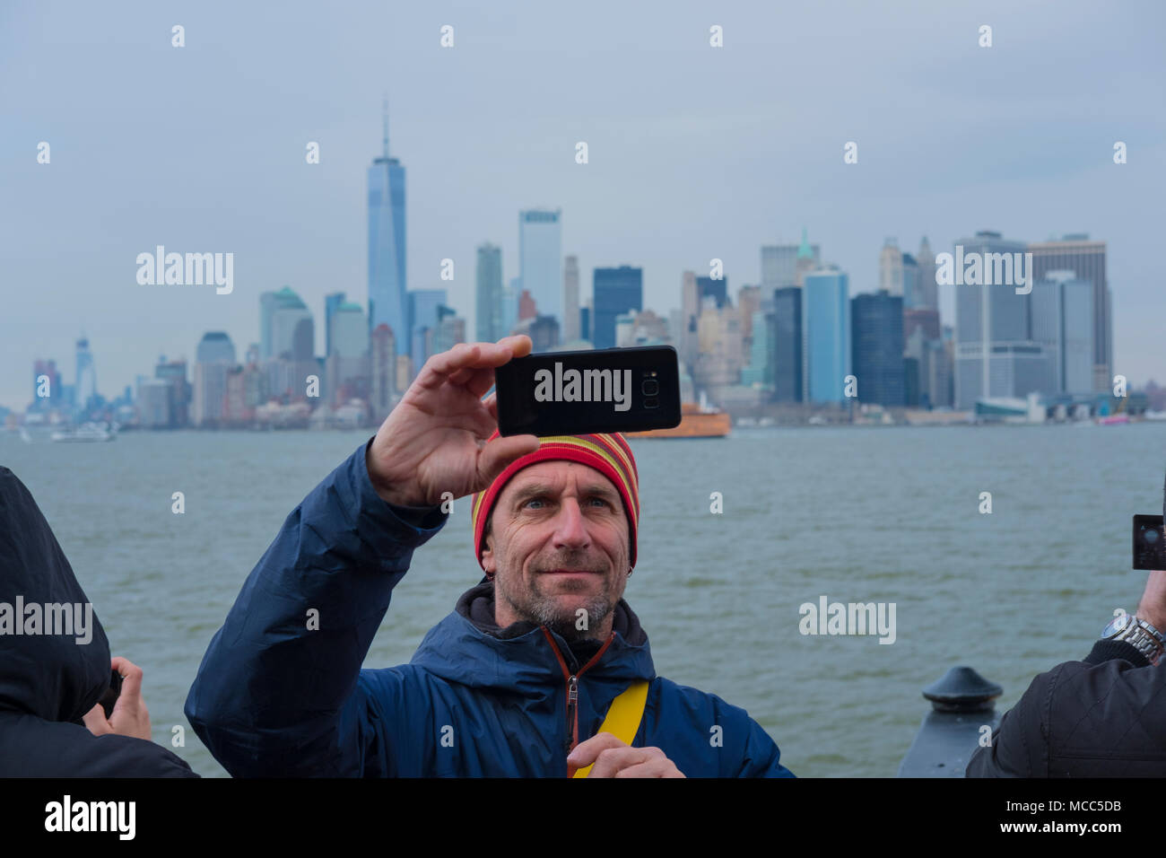 Staten Island Selfie: dieser Herr scheint mit seinem schoß auf die Skyline von Manhattan erfreut, als er vom Staten Island auf der Fähre zurück, April 2018. Stockfoto
