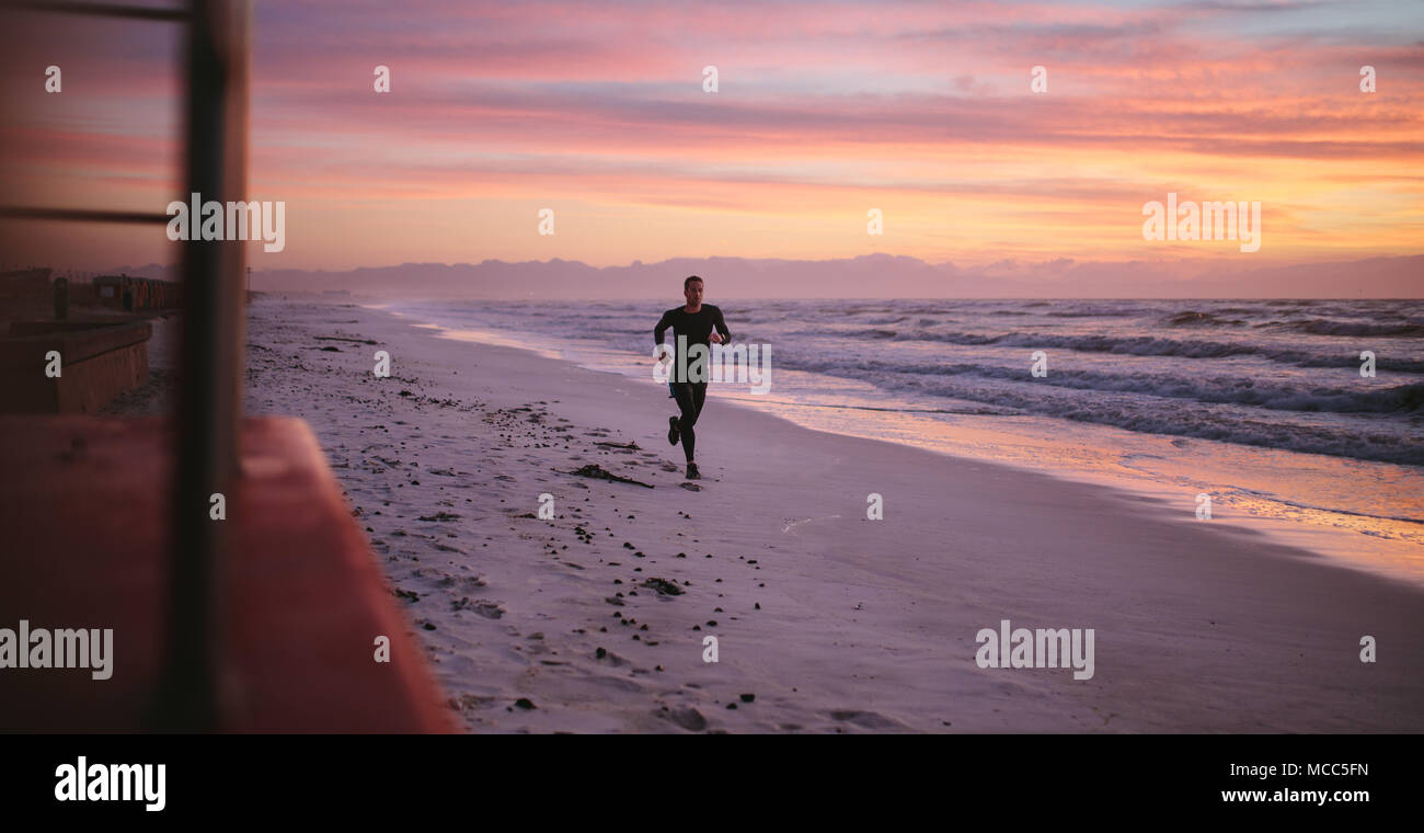 Mann Training am Strand von Morgen. Gesunde männliche Athleten auf Morgen laufen draußen am Meer. Stockfoto