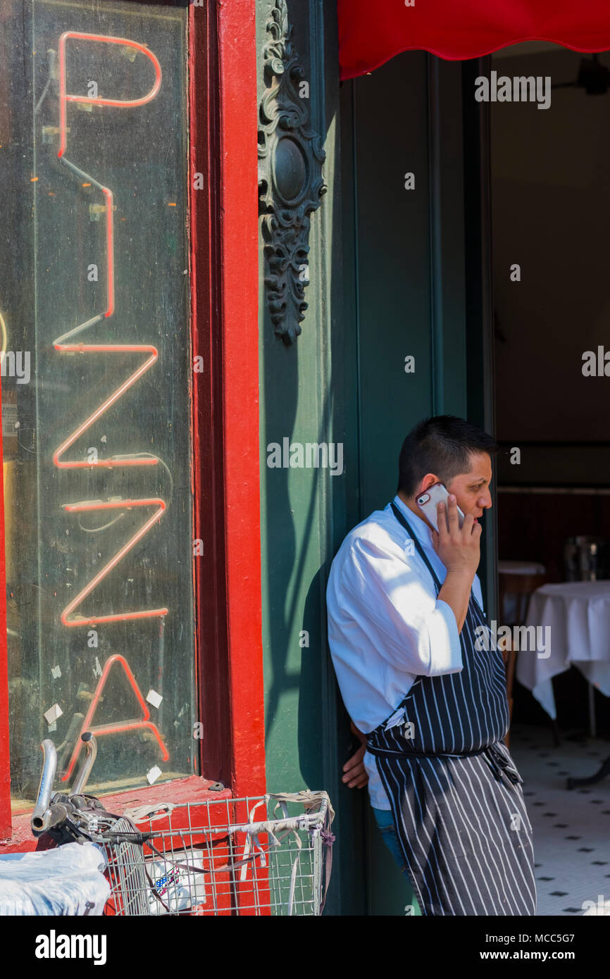 Dieser Kellner ist wahrscheinlich nicht telefonieren, für Pizza in New Yorks Greenwich Village, April 2018 Stockfoto