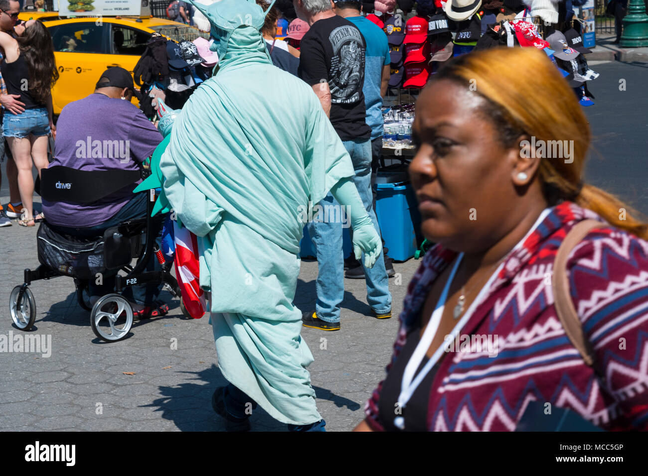 Lady Liberty scheint ihr zurück zu drehen auf dieser Afro-amerikanische Frau, Battery Park, New York City, April 2018 Stockfoto