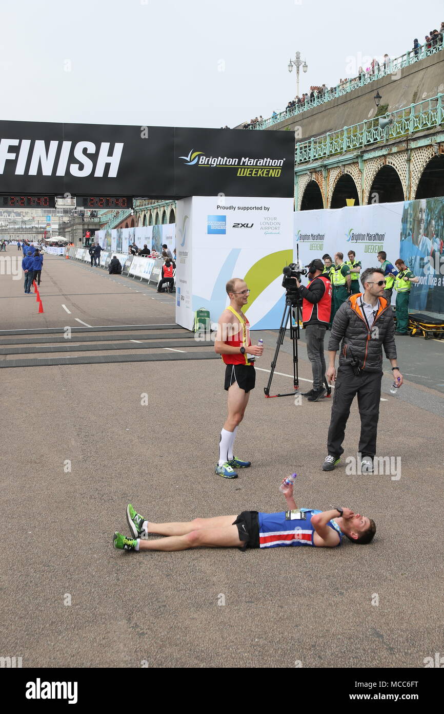 Ein Läufer flach auf dem Boden am Ende der Brighton Marathon Stockfoto