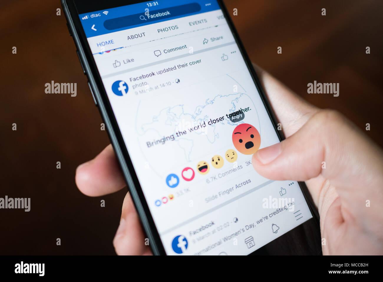 Bangkok, Thailand - 27. März 2018: Facebook User Touch auf Wütend Schaltfläche in Facebook Applikation auf dem iPhone 7. Stockfoto