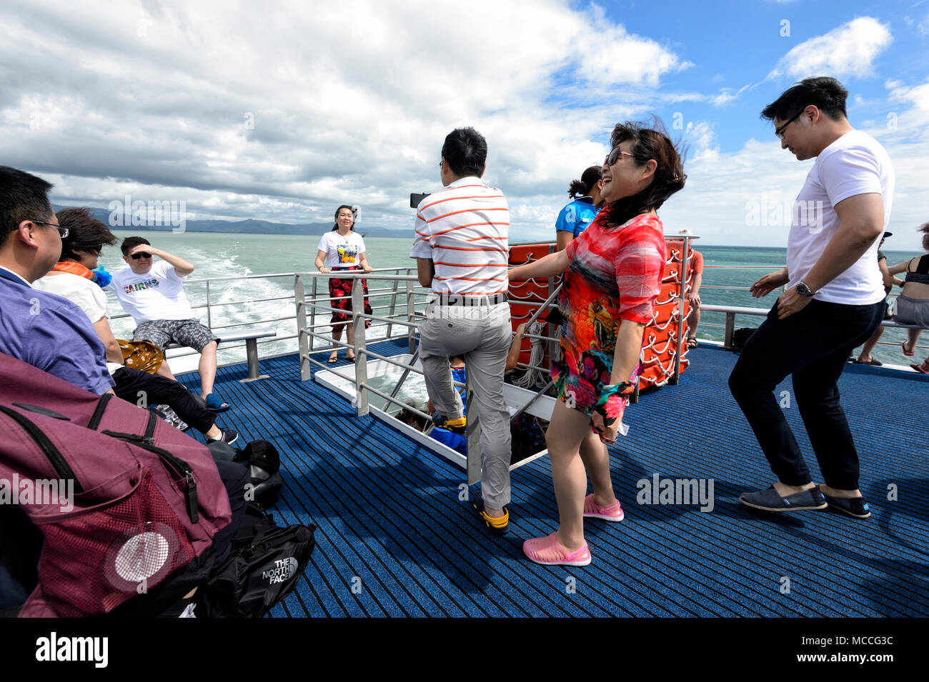 Chinesische Touristen Spaß Aufnahmen an der Rückseite des Bootes während der Kreuzfahrt am Great Barrier Reef, Far North Queensland, Queensland, FNQ, Australien Stockfoto