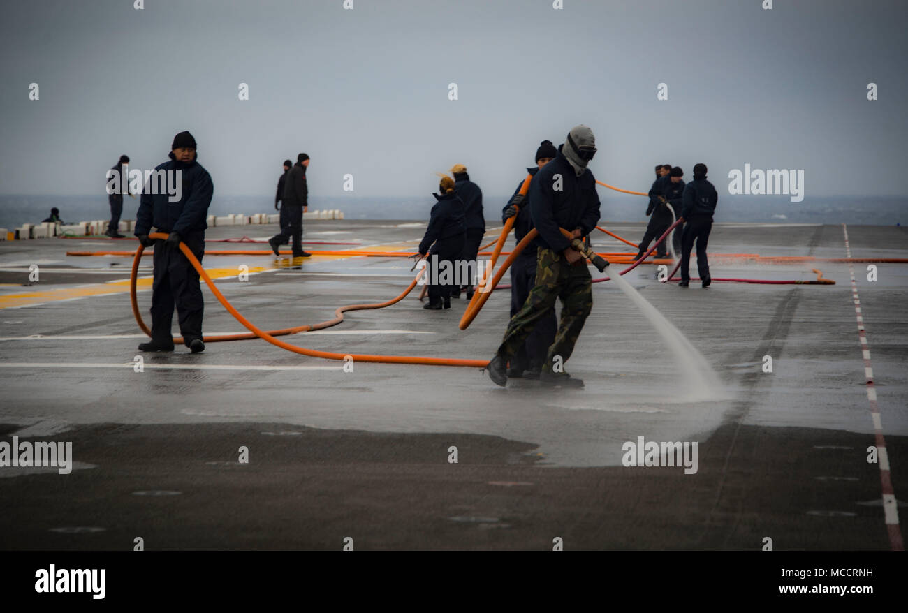 Atlantik (Feb. 8, 2018) Segler Wash Down das Flight Deck der Amphibisches Schiff USS Iwo Jima (LHD7). Die Iwo Jima Amphibious Ready Group (ARG) ist zur Unterstützung der Maritime Security Operations und Theater Sicherheit Zusammenarbeit in Europa und im Mittleren Osten eingesetzt werden. Die Iwo Jima ARG begibt sich die 26 Marine Expeditionary Unit und umfasst die Iwo Jima, die amphibious Transport dock Schiff USS New York (LPD-21), das Dock Landung Schiff USS Oak Hill (LSD 51), Flotte Op-Team 8, Hubschrauber Meer Combat Squadron 28, Tactical Air Control Squadron 22, Komponenten der Naval Beach Gruppe 2 ein Stockfoto