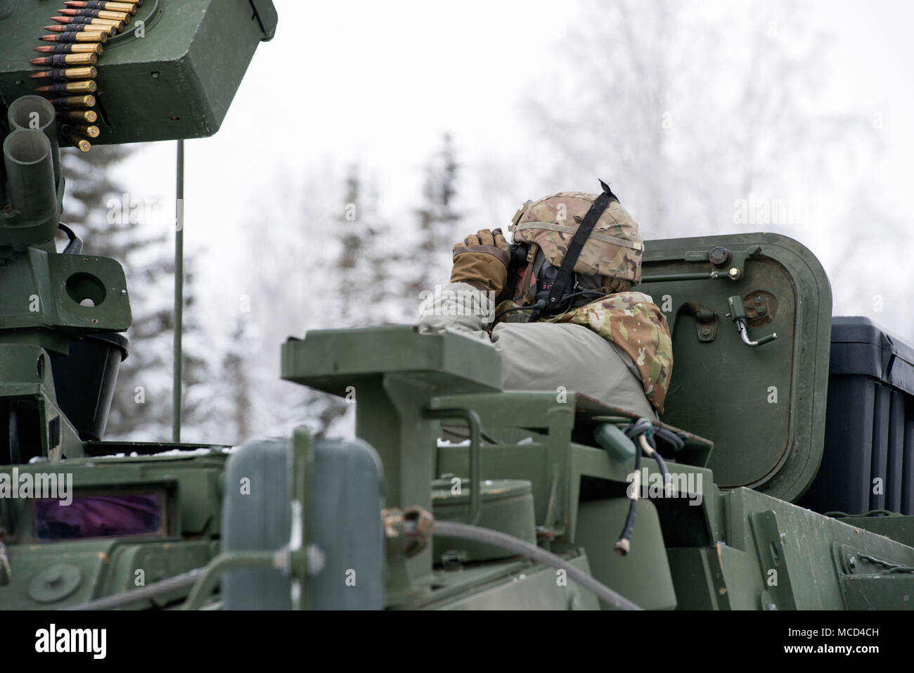 Ein Soldat Bajonett Unternehmen, 1.BATAILLON, 5 Infanterie Regiment, 1 Stryker Brigade Combat Team, 25 Infanterie Division, U.S. Army Alaska zugeordnet, Erhebungen der Umgebung während der Vorbereitung für Live-fire Schießwesen Ausbildung im Betrieb Punchbowl bei Joint Base Elmendorf-Richardson, Alaska, Feb 16, 2018. Betrieb der Punchbowl war ein Bataillon, kombinierte Waffen, Feuer, die auf Arktis Letalität konzentriert. (U.S. Air Force Foto von Alejandro Peña) Stockfoto