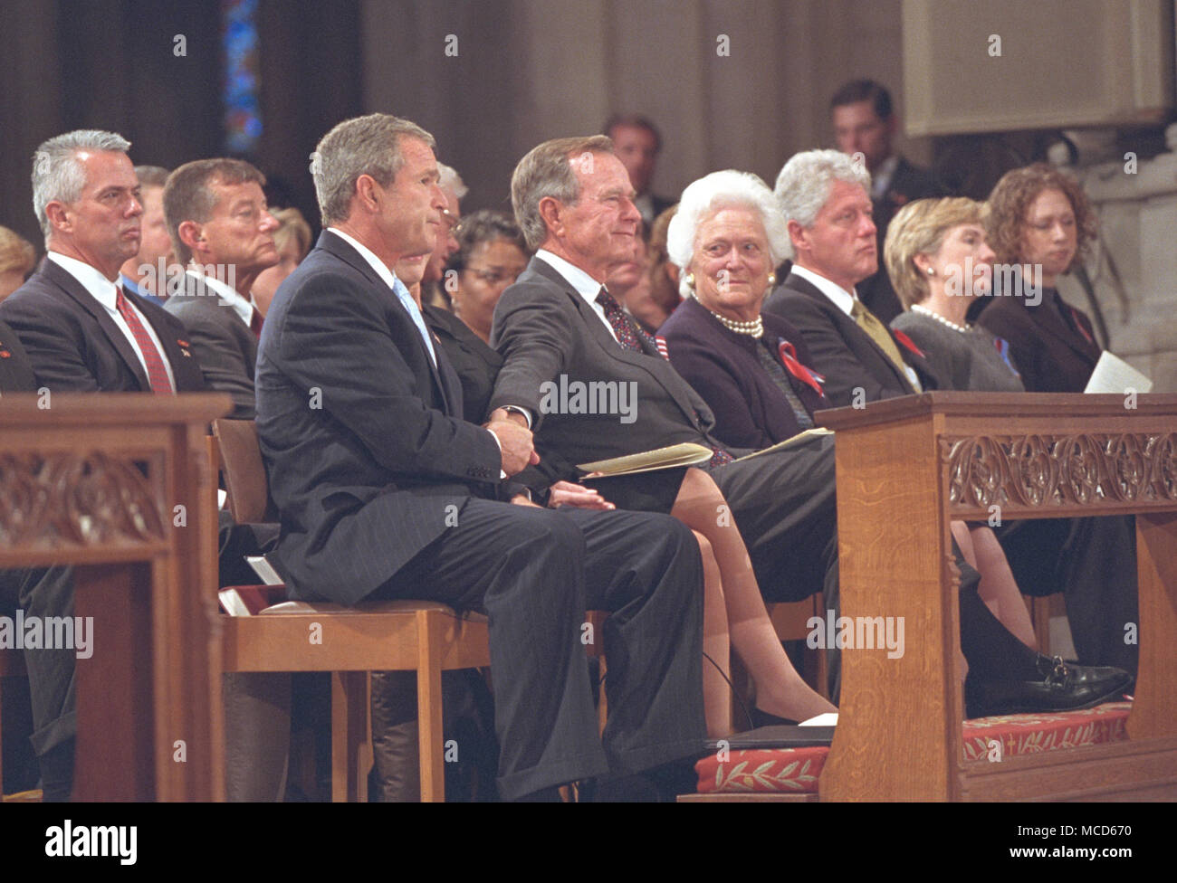 Nach dem Gespräch am Service für Amerikas nationalen Tag des Gebets und des Gedenkens an der Washington National Cathedral in Washington, DC am Freitag, 14. September 2001, Präsidenten der Vereinigten Staaten George W. Bush greift die Hand seines Vaters, des ehemaligen Präsidenten George H.W. Bush. Auch sichtbar auf dem Foto sind ehemalige First Lady Barbara Bush, ehemalige US-Präsident Bill Clinton, US-Senatorin Hillary Rodham Clinton (Demokrat von New York) und Chelsea Clinton.Mandatory Credit: Eric Draper - White House über CNP./MediaPunch Stockfoto