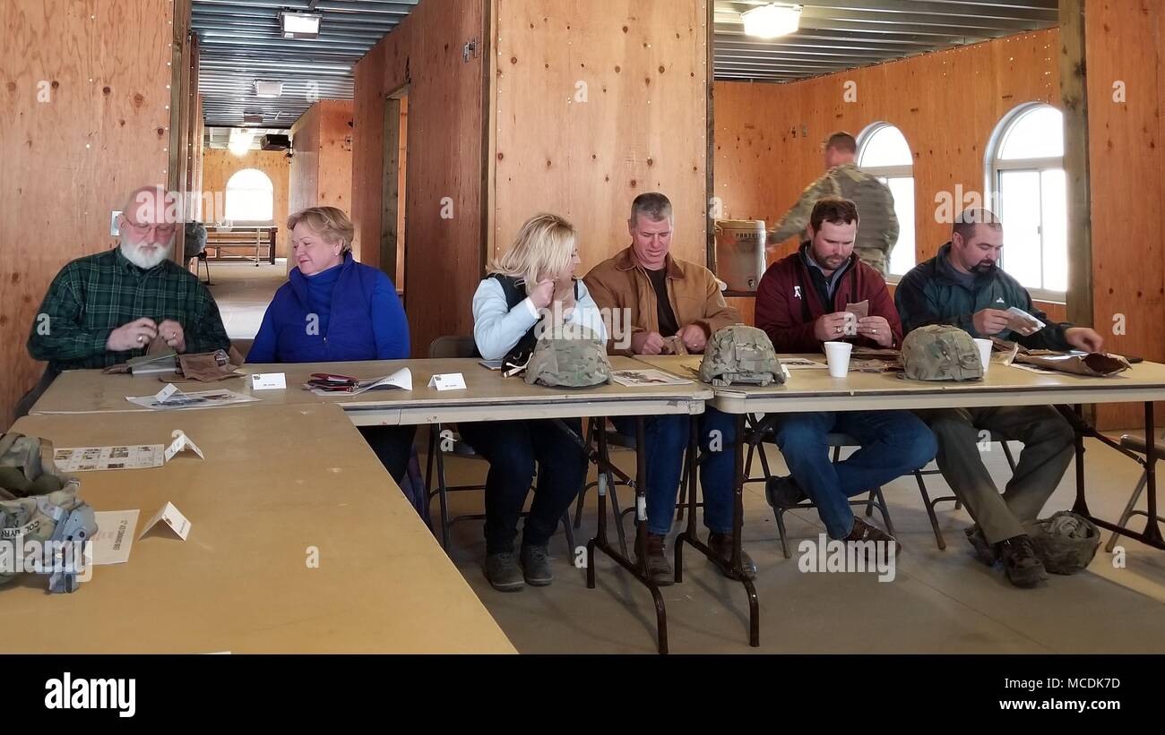 Mitglieder der Killeen und Harker Heights Handelskammern essen Mahlzeiten Ready-to-Eat in der mock Governor's Mansion in der fiktiven Stadt Razish am National Training Center, Fort Irwin, Calif., Feb 18, 2018. Das Killeen und Harker Heights Handelskammern NTC-Besuch ist entworfen, um die Beziehungen zwischen den bürgerlichen Führern in der Umgebung Fort Hood Gemeinschaft und Service Mitglieder in Fort Hood, Texas, zugeordnet zu stärken. (US Army Foto von Maj. Anthony Clas, 7 Mobile Public Affairs Abteilung) Stockfoto