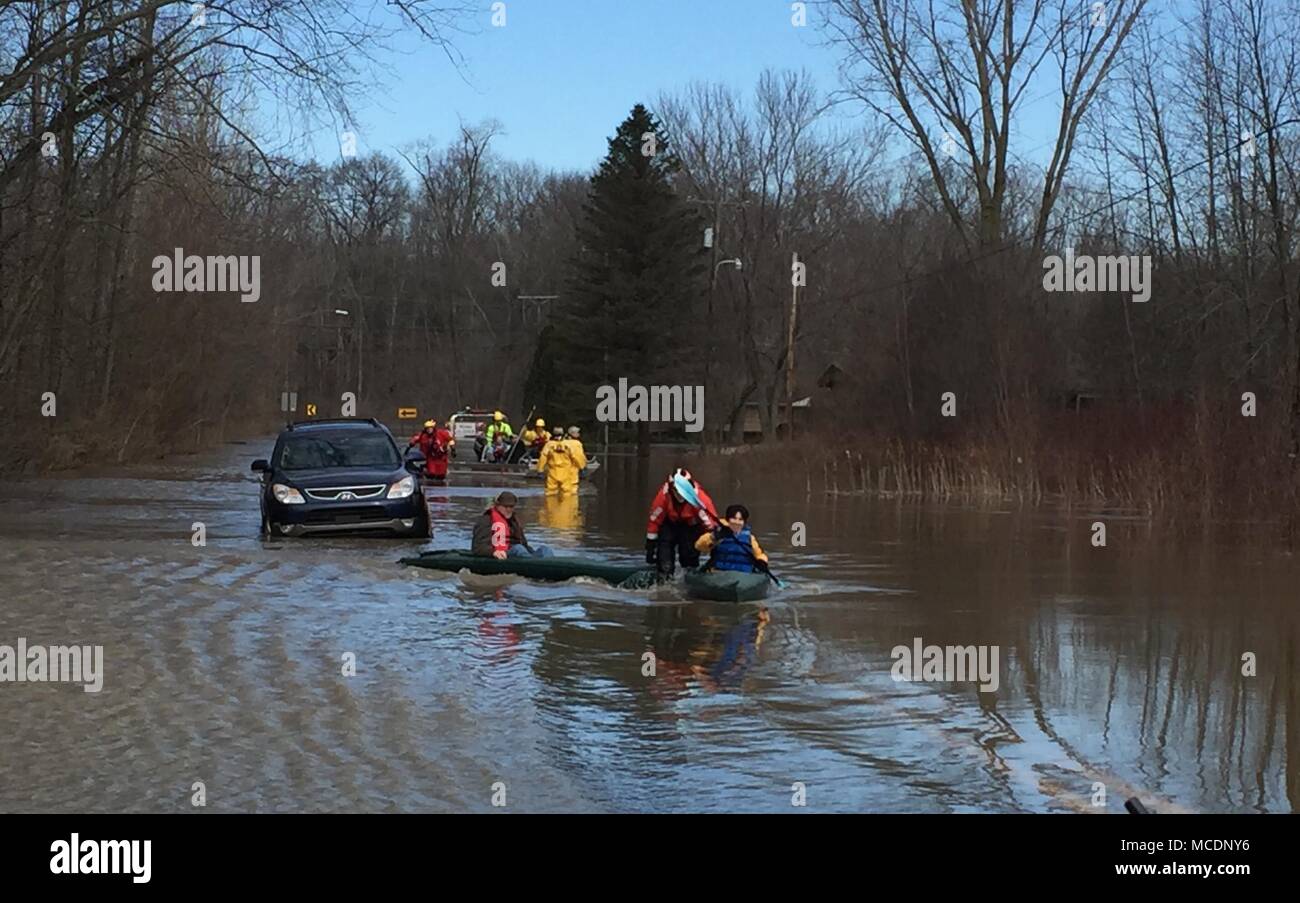 Mitglieder von der Coast Guard Station St. Joseph's Ice-Rescue Team bei der Evakuierung der Personen aus ihren Häusern in der Nähe von St. Joseph, Michigan, durch Überschwemmungen durch starken Regen- und Schmelzwasser, Feb 22, 2018 aufzeichnen. Das Hochwasser waren mehr als zwei Meter höher als alles, was vorher in der Umgebung erlebt. (U.S. Coast Guard Foto) Stockfoto