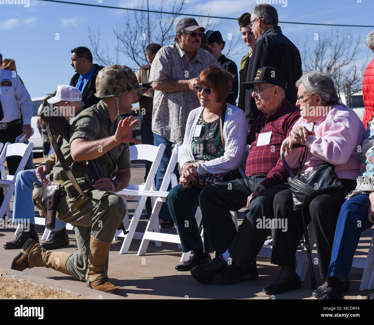 Ein Veteran und seiner Familie sprechen Sie mit einem der Marine reenactors nach einem Flammenwerfer demonstration Feb.17, 2018, an der Wellington Bankett Center in Wichita Falls, Texas. Reenactors, die tatsächlich aktive militärische Aufgabe Mitglieder selbst, auf eine Show für die Veteranen. Nicht nur, dass die Macht der Flammenwerfer demonstrieren, ein integraler Bestandteil des Zweiten Weltkriegs, sondern auch die berühmten Hebung der amerikanischen Flagge auf Mount Suribachi, Iwo Jima geschlechtsgeruches. (U.S. Air Force Foto von Airman 1st Class Pedro Tenorio) Stockfoto