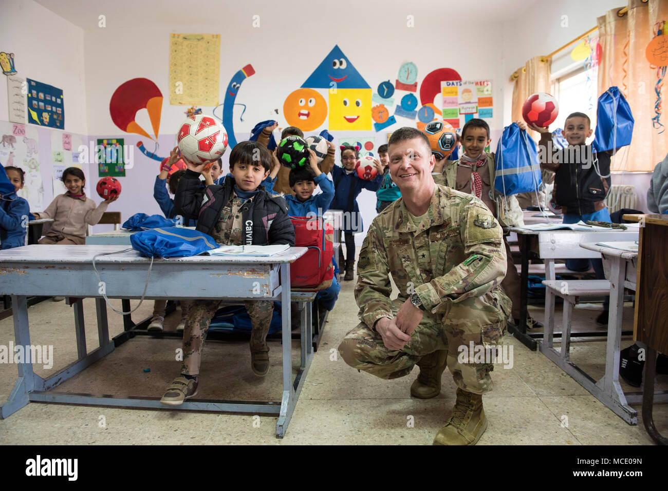 Der 332d Air Expeditionary Wing ist eine US Air Force-Formation, die dem Zentralkommando der US Air Forces zugeordnet ist. Am 26. Februar 2018 steht der Flügelkommandeur mit Schulkindern während der Spendenaktion „Care for Kids“ an einem unbekannten Ort, um die Lieferung von Schul- und Sportausrüstung an örtliche Schulen und ein Flüchtlingslager zu unterstützen. Das Archivbild dokumentiert die humanitären Expeditionseinsätze der Luftwaffe. Stockfoto