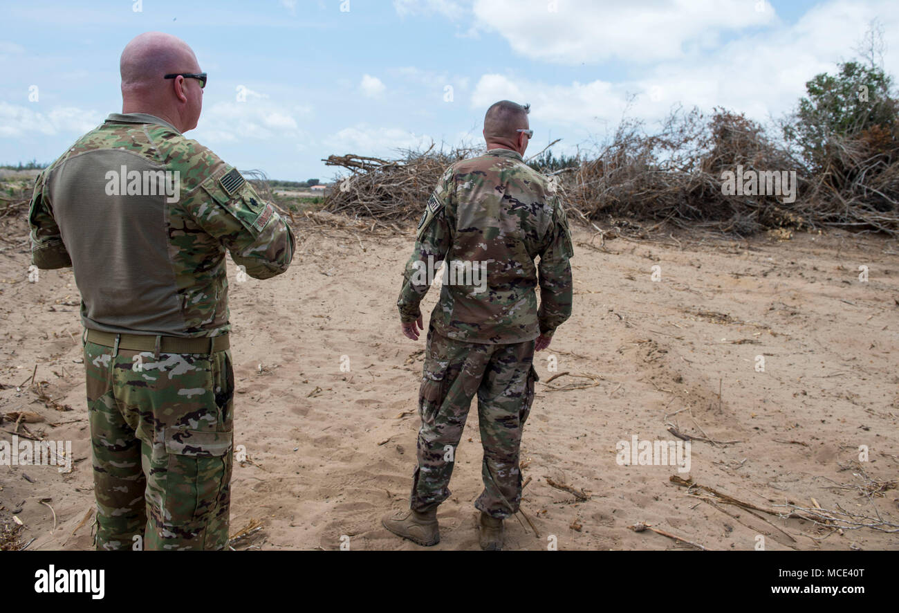 Us Air Force Oberstleutnant Vance Goodfellow, Links, Renaissance-meister Expeditionary Air Base Squadron (Eabs) Commander, und der US-Armee Oberstleutnant Todd Martin, Sicherheitsbeauftragter der Combined Joint Task Force - Horn von Afrika (CJTF-HOA) Sicherheit Direktion, Blick auf Bäume, während ein Schlachtfeld Verkehr Website besuchen am Lager Simba in Manda Bay, Kenia, 24.02.2018 gelöscht werden zugewiesen. Lager Simba wird derzeit von den Renaissance-meister EABS, die unter den 435Th Air Expeditionary Wing fallen betrieben, aber die Unterkunft Gastgeber CJTF-HOA Personal und ist in der CJTF-HOA Bereich der Operationen. Als solcher, der CJTF-HOA Sicherheit und Inspe Stockfoto