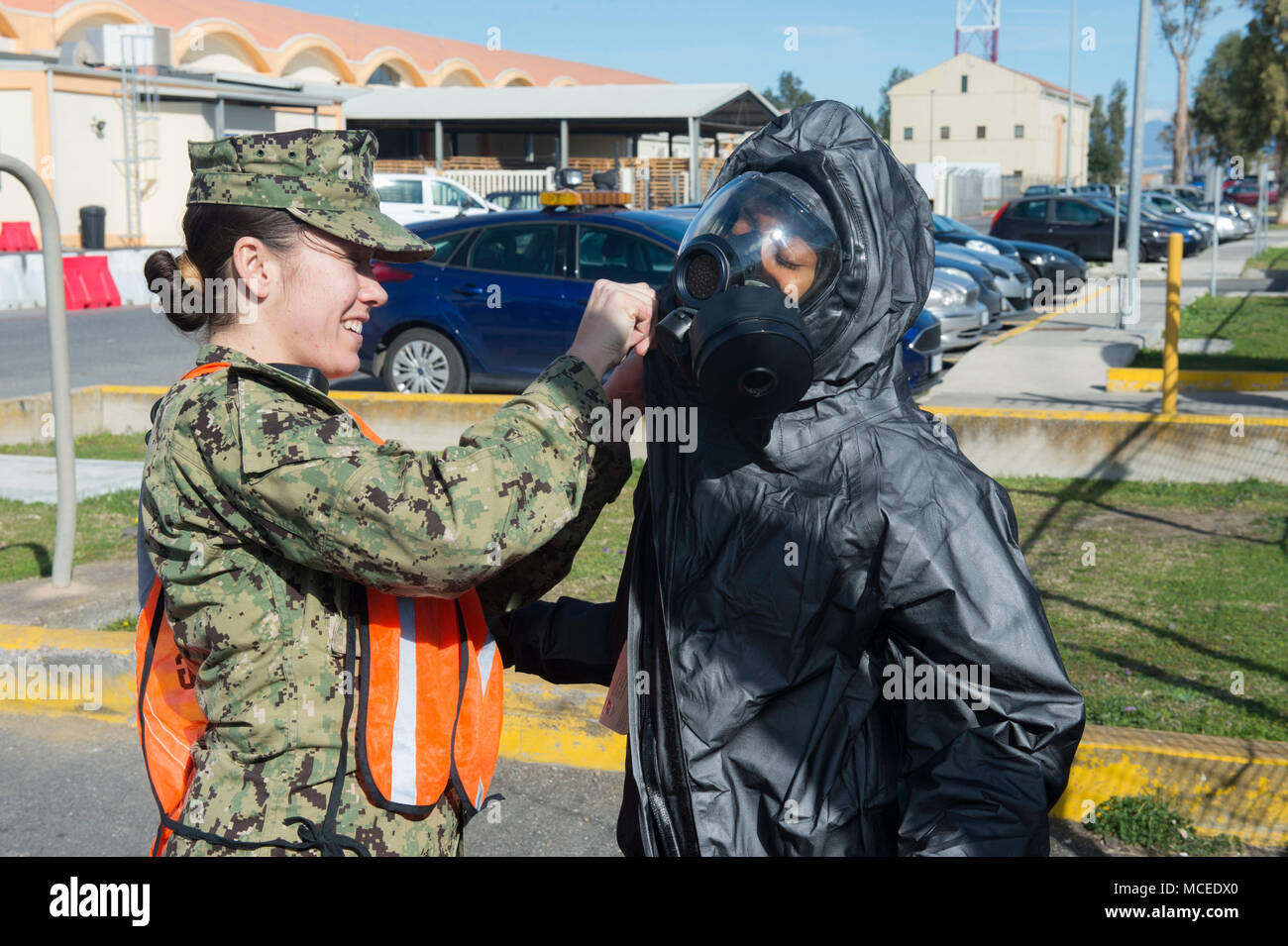 180220-N-OY 339-023 SIGONELLA, Sizilien (Feb. 20, 2018) Master-at-Arms 3. Klasse Kristie Lewis unterstützt Master-at-Arms 2. Klasse Antoinette Howell, der in eine haszardous Materialien Klage auf Abschluss eines biologischen Waffen Angriff Bohrer an Naval Air Station (NAS) Sigonella. NAS Sigonella ist ein operationelles an Land, die USA ermöglicht, Verbündeten und Partner nation Kräfte zu werden, wo sie benötigt werden und wenn sie sind, um die Sicherheit und Stabilität in Europa, Afrika und Südwestasien. (U.S. Marine Foto von Mass Communication Specialist 2. Klasse Christopher Gordon/Freigegeben) Stockfoto