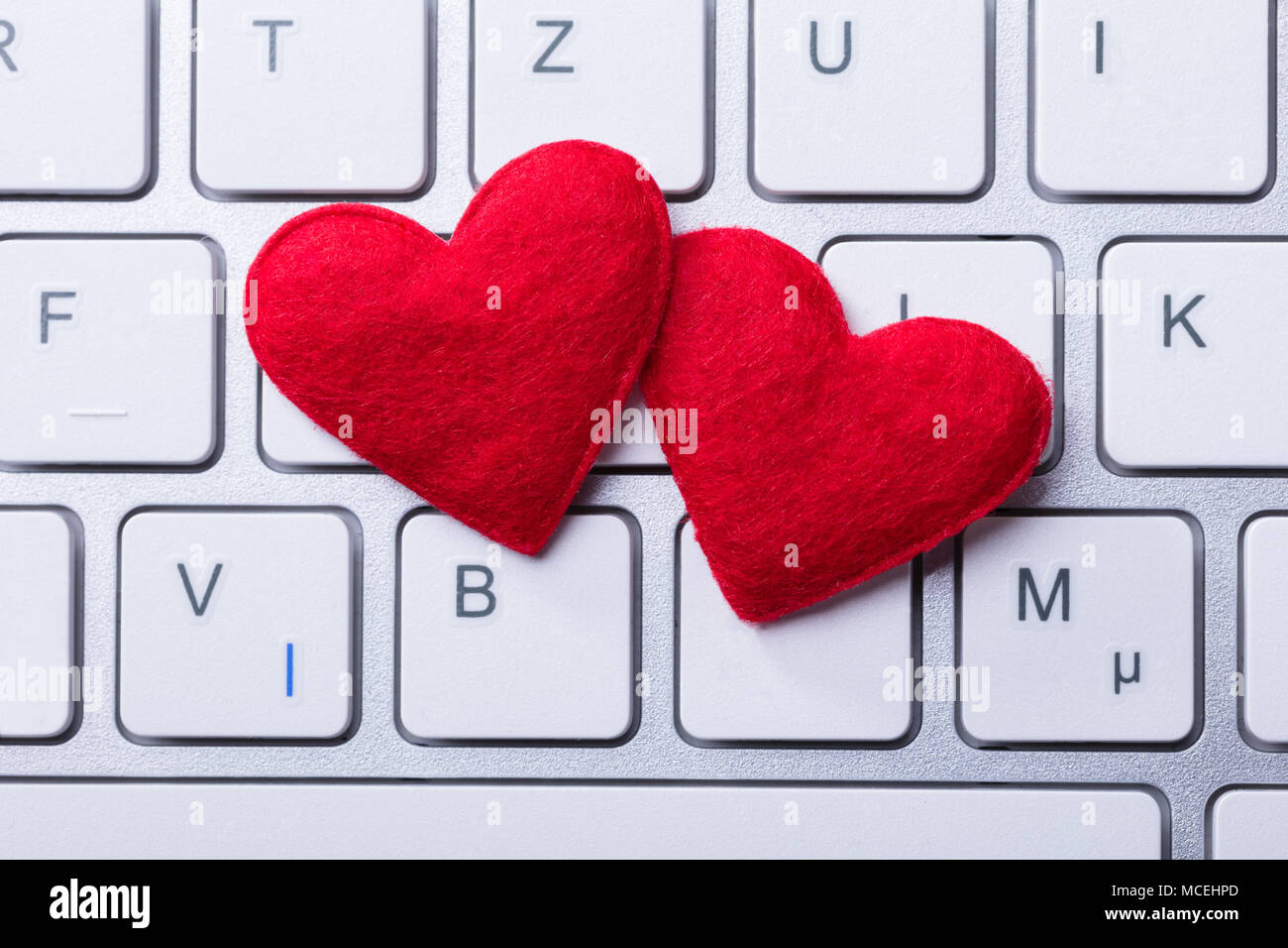 Erhöhten Blick auf Weiche Zwei rote Herzen Form auf der Tastatur Stockfoto