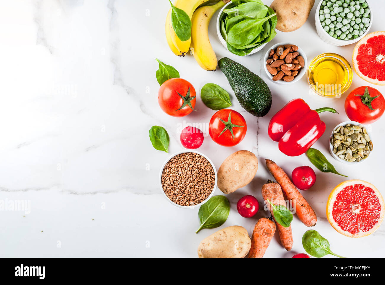 Gesundes essen Hintergrund, trendige Basische Ernährung Produkte - Obst, Gemüse, Getreide, Nüsse. Öle, weißem Marmor Hintergrund oben Stockfoto