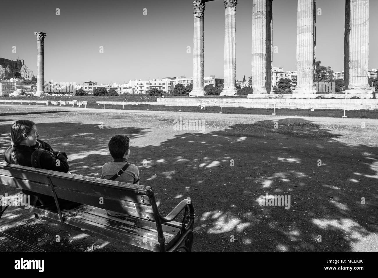 Mutter mit Sohn sitzt auf der Bank vor dem Tempel des Olympischen Zeus, Athen, Griechenland Stockfoto