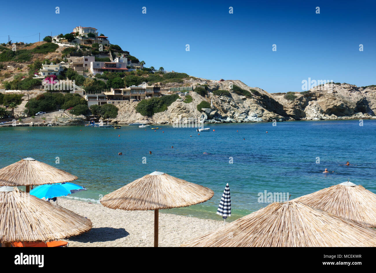 Der Sonnenschirm am Strand mit Küsten Häuser am hügel, Heraklion, Griechenland Stockfoto