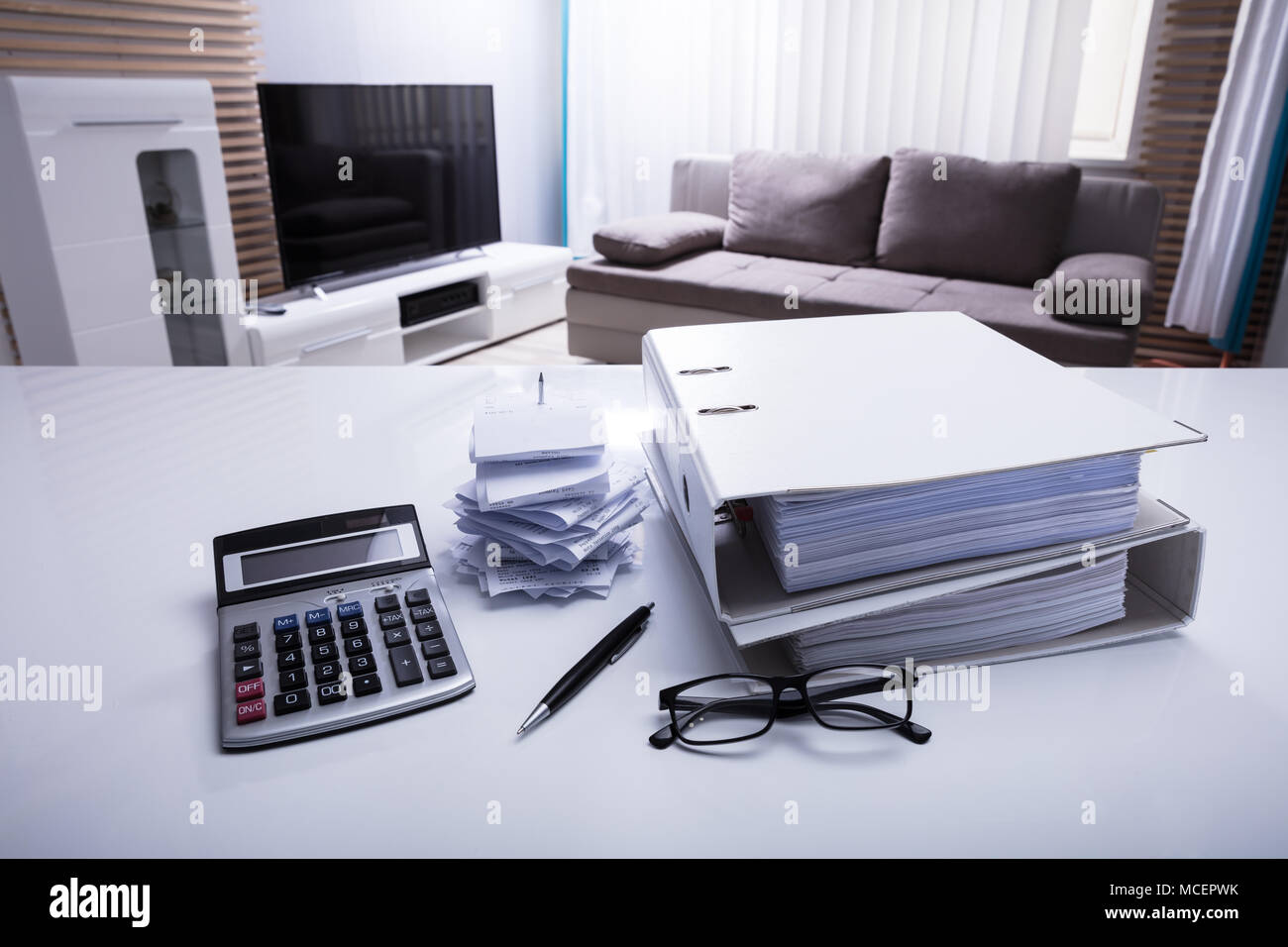 Close-up von Ordnern mit Quittungen und Taschenrechner auf weißem Schreibtisch im Schlafzimmer Stockfoto