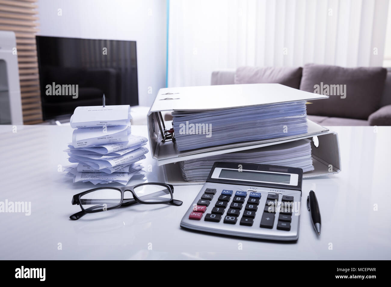 Close-up von Ordnern mit Quittungen und Taschenrechner auf weißem Schreibtisch im Schlafzimmer Stockfoto