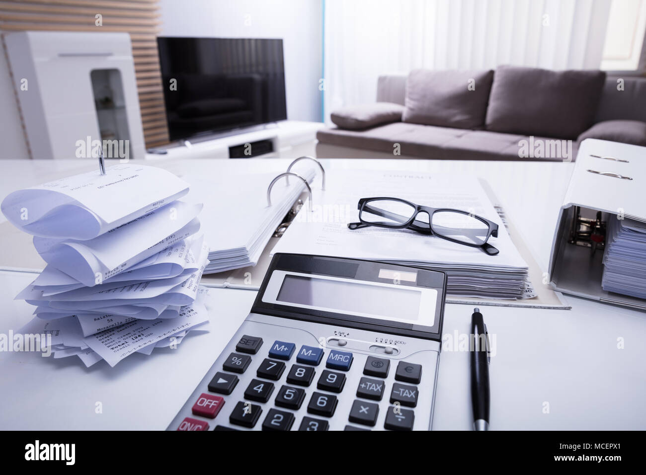 Close-up von Ordnern mit Quittungen und Taschenrechner auf weißem Schreibtisch im Schlafzimmer Stockfoto