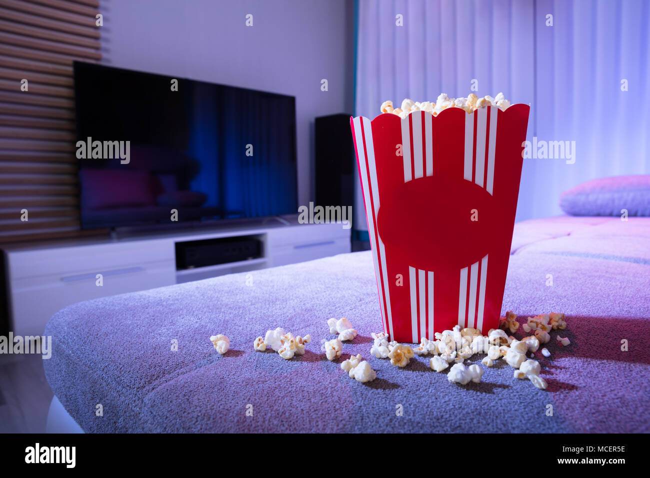 In der Nähe von Popcorn auf der Couch im Wohnzimmer bei Nacht Stockfoto