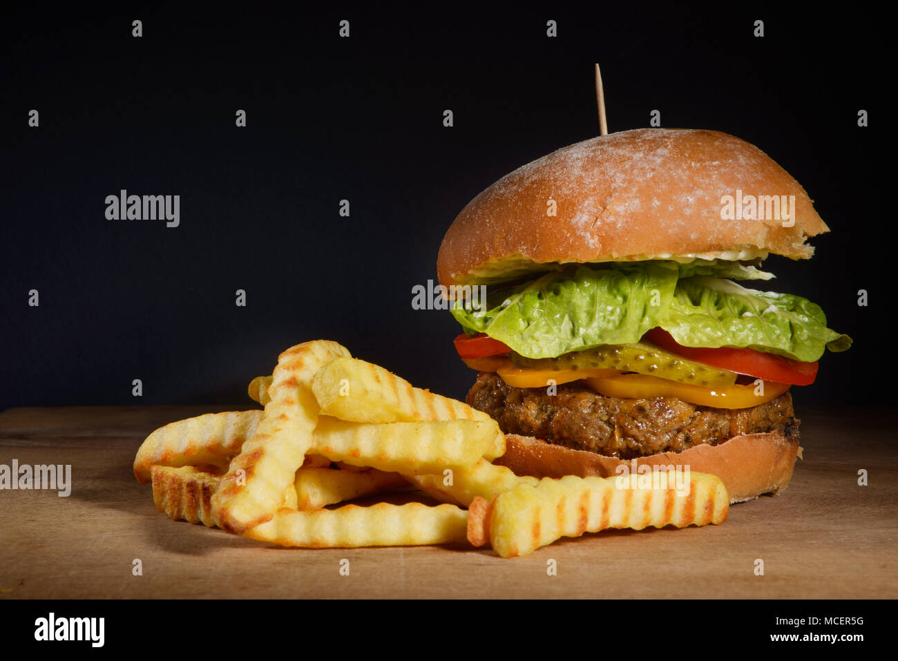 Burger und Pommes Frites mit dunklem Hintergrund Raum Stockfoto