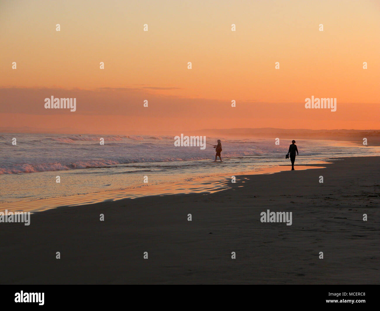 Strand Fischer und Wanderer durch das Meer bei Sonnenuntergang, Anna Bay, Stockton Beach, New South Wales, Australien, S Stockfoto