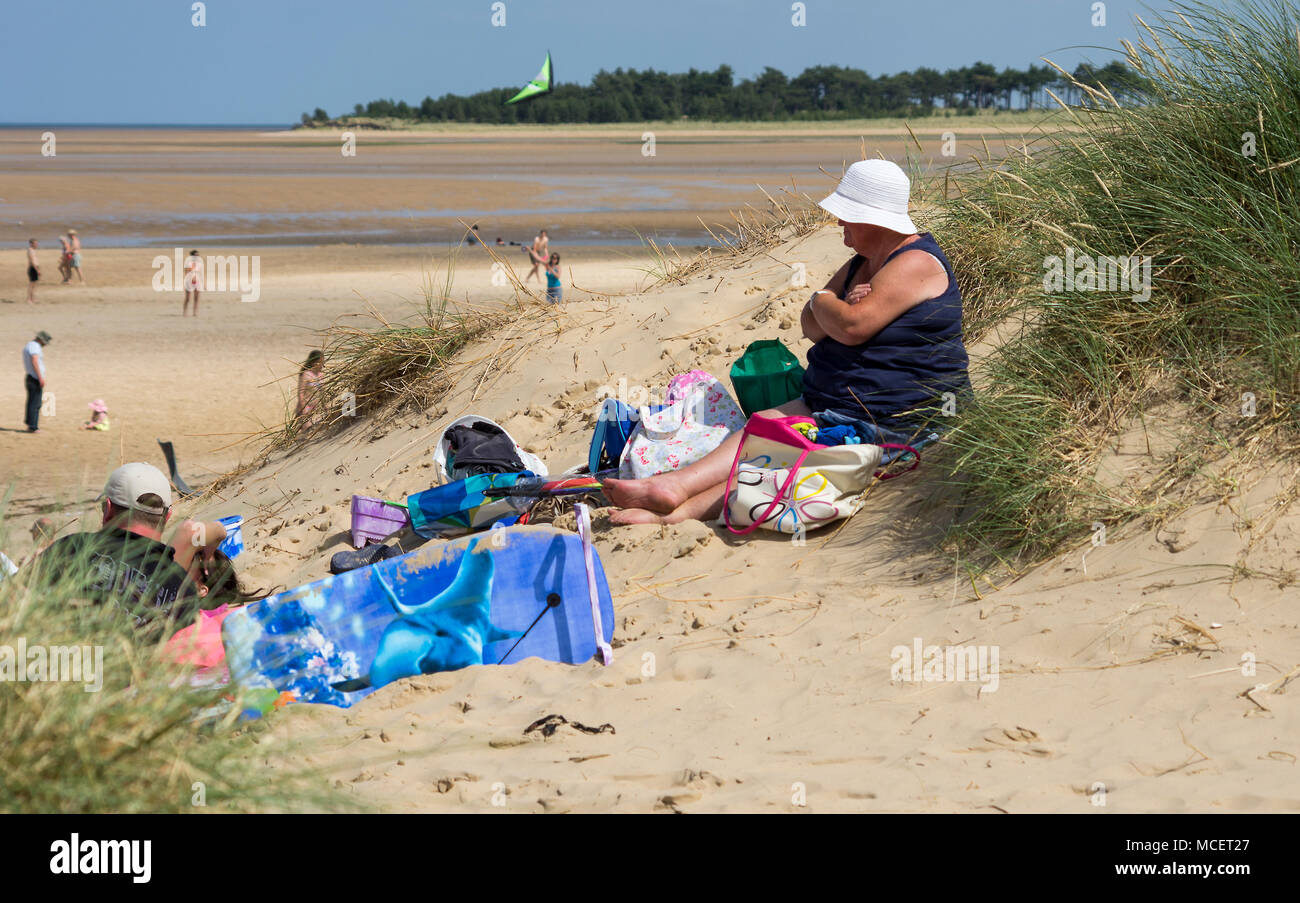 Eine Frau auf einer Düne mit einem Buch sitzen Stockfoto