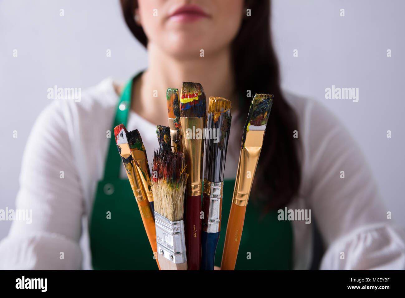 Close-up verschiedener Pinsel Vor der Künstlerin Stockfoto