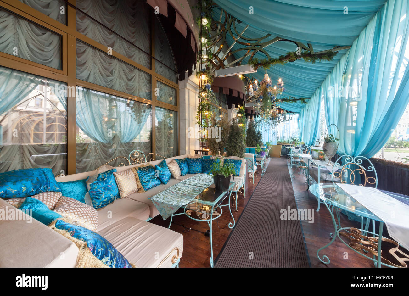 Moskau - AUGUST 2014: Vintage Interieur des Restaurants der Französischen Küche "Chateau de Fleurs". Terrasse mit Sofas und Tischen unter einem Stoff t Stockfoto