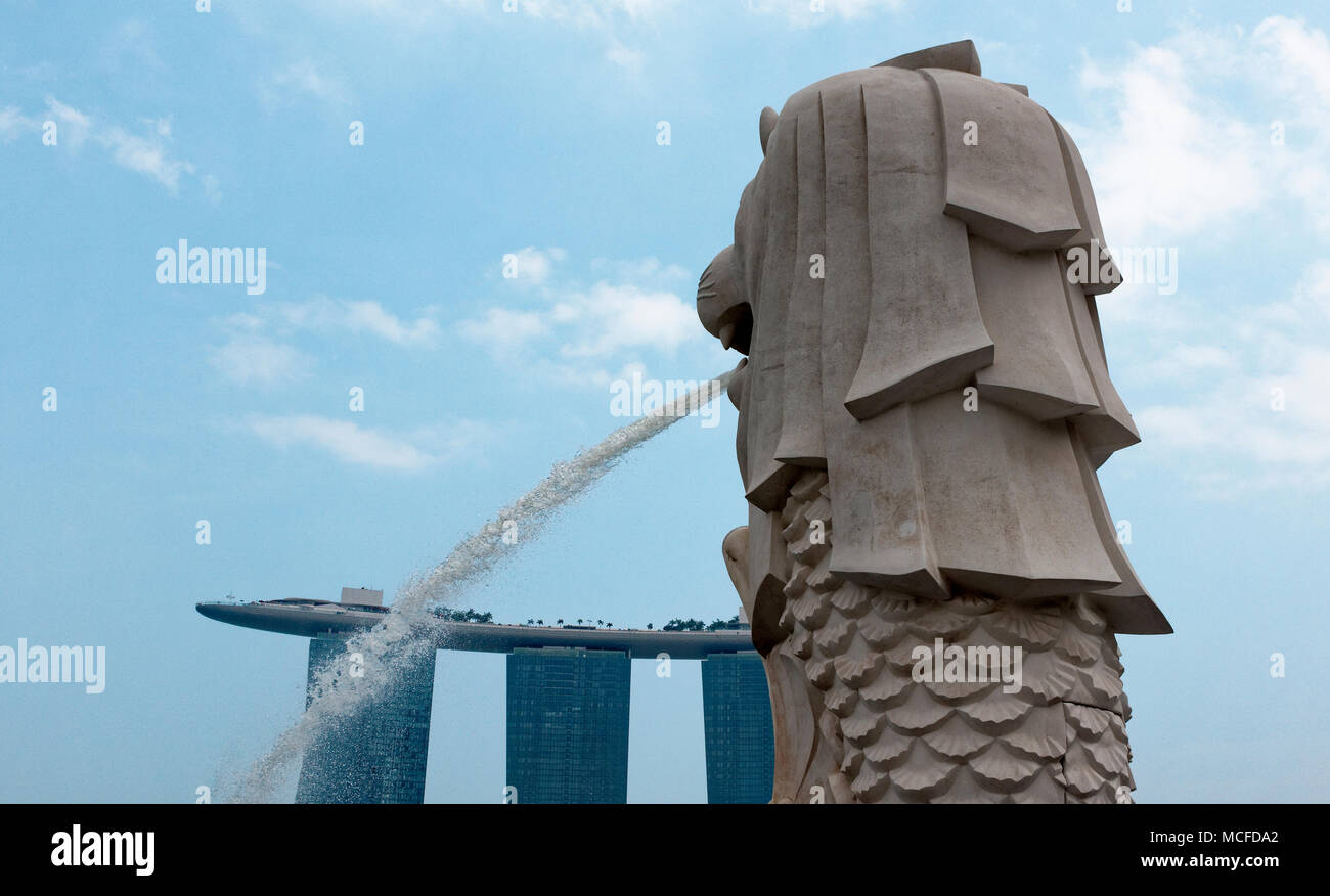 Das fließende Wasser Auslauf der Sehenswürdigkeiten Singapur Merlion mit Marina Bay Sands im Hotel im Hintergrund. Stockfoto