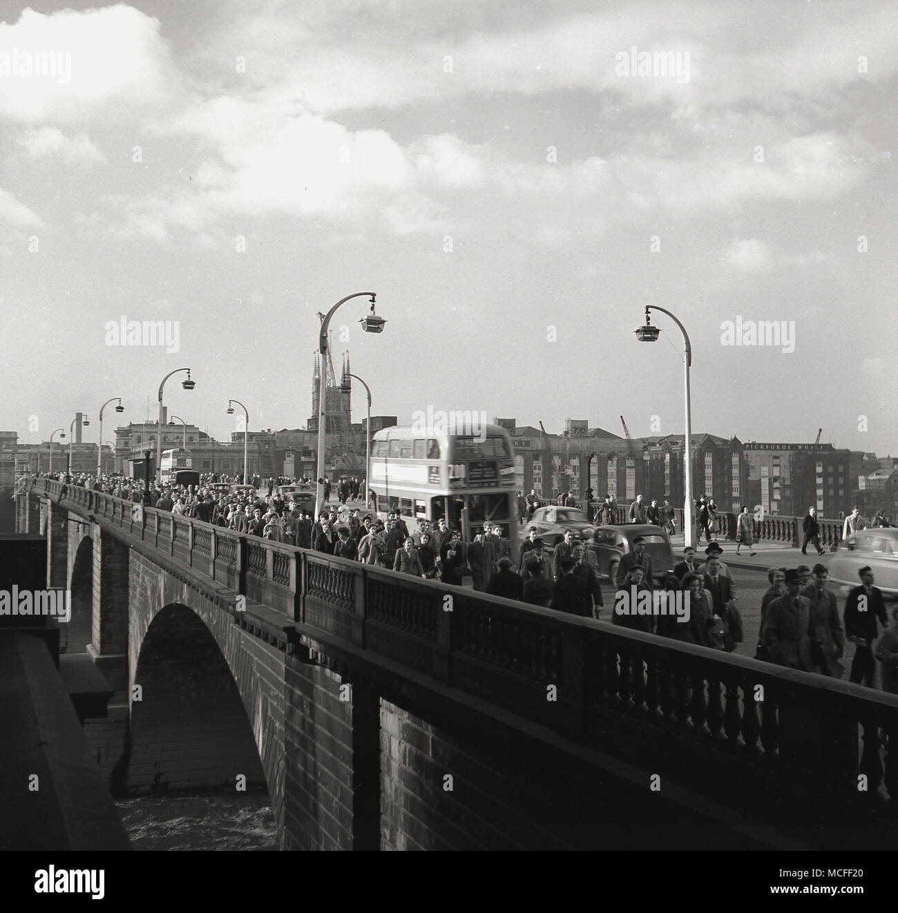 London, 1948, Überqueren von 'neuen' London Bridge von Southwark, die auf dem Weg zur Arbeit in London, England. Von John Rennie konzipiert, es öffnete sich 1831 und bestand aus 5 steinernen Bögen und ersetzt die früheren mittelalterlichen Brücke. Die Brücke wurde den verkehrsreichsten Punkt in London und einer der verkehrsreichsten, mit Tausenden von Fußgängern und Fahrzeugen es jede Stunde Überfahrt. Stockfoto