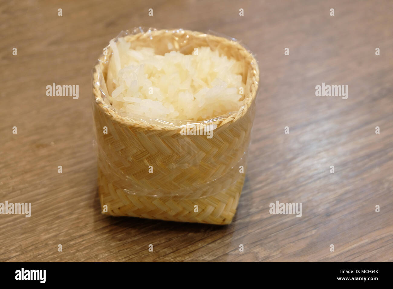 Klebriger Reis in Bambus Schale auf Holz Tisch Stockfoto
