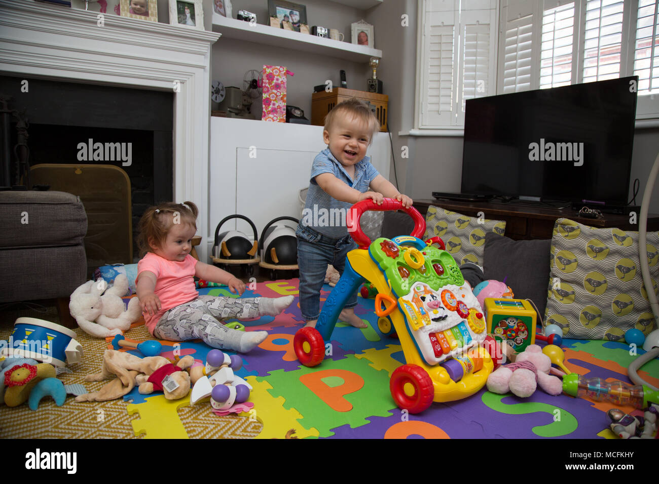 Babys, die mit ihren Spielsachen spielen. Stockfoto
