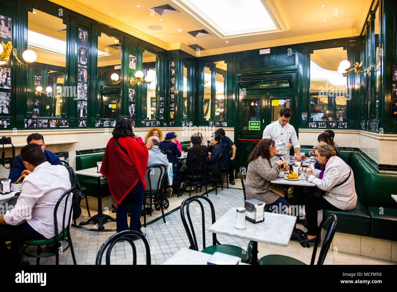 Menschen essen Churros in einem Cafe, Interieur des Trinken San Gines - die älteste churreria und Trinken in Madrid, Spanien Stockfoto