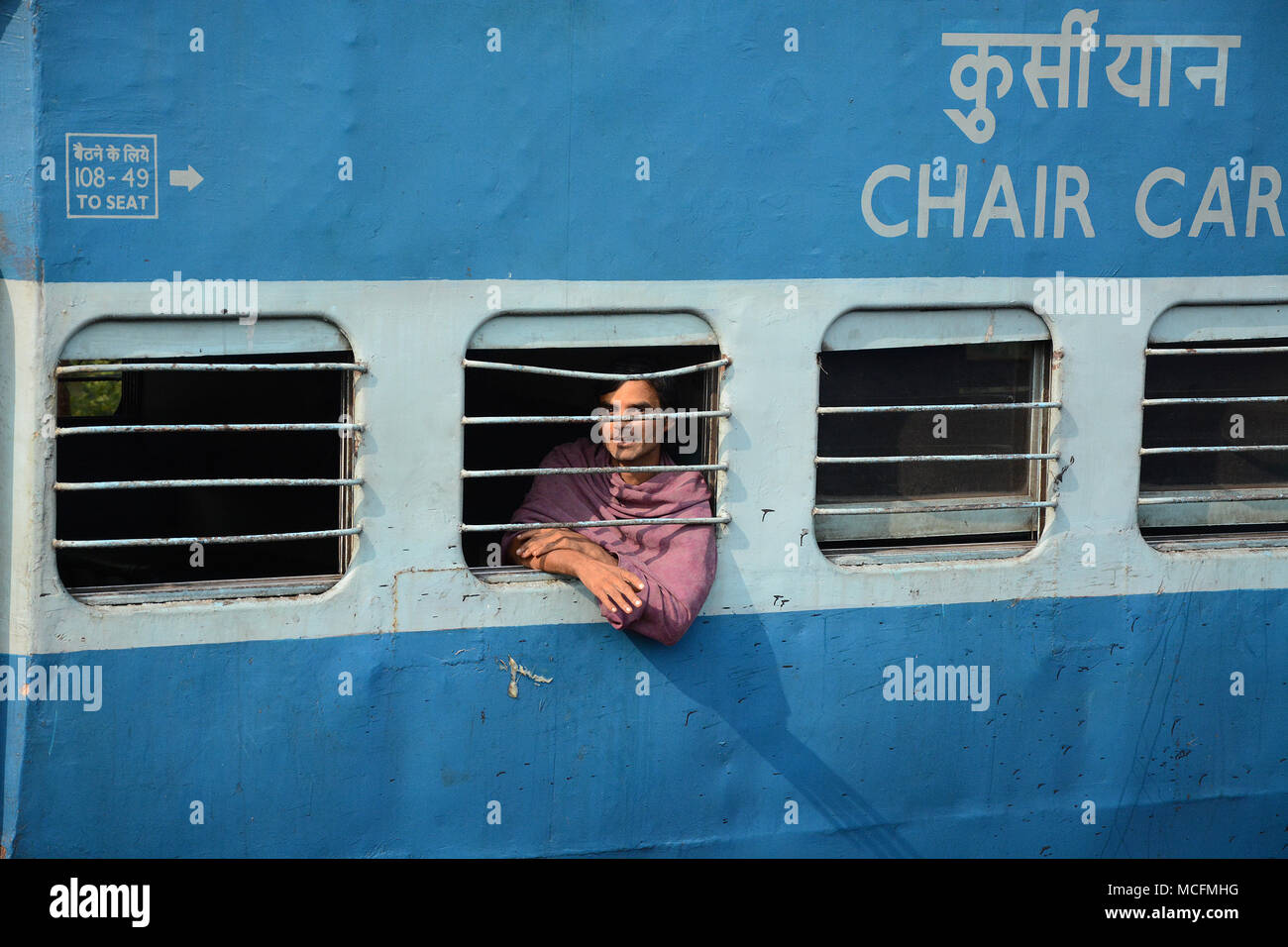 Man schaut aus dem Fenster auf einen vorbeifahrenden Zug in Indien Stockfoto